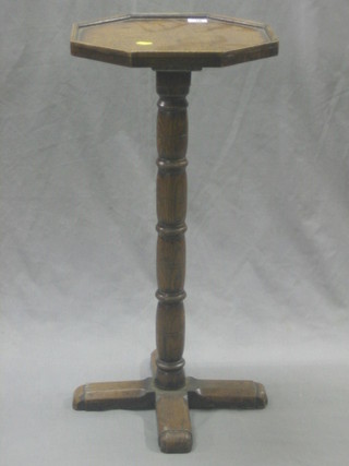 An octagonal oak wine table, raised on a turned column with X foot 13"