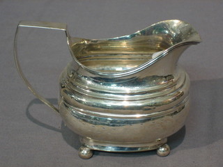 A Georgian engraved silver cream jug raised on 4 bun feet, 3 ozs marks rubbed