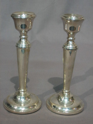 A pair of modern silver candlesticks with bead work borders 7"