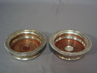 A pair of Georgian style circular silver bottle coasters with rope edge borders by Mappin & Webb