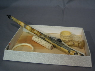 A carved horn opium pipe, an ivory dagger and sheath, an ivory bangle, do. napkin ring, needle case, brooch, cigarette holder and figure