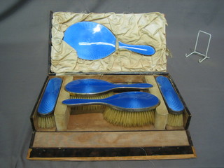 An Art Deco silver and blue enamel 6 piece dressing table set comprising pair of hair brushes, pair of clothes brushes, comb mount and hand mirror, cased, London 1926