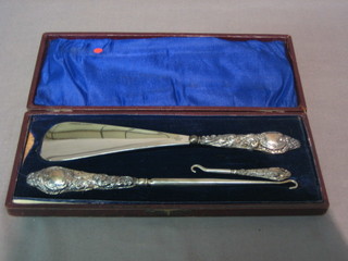 A silver handled shoe horn and 2 silver handled button hooks, cased