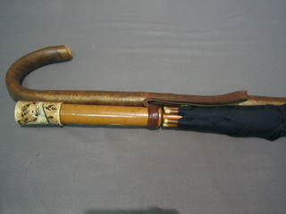 An Eastern parasol with engraved ivory handle decorated a figure and a wooden walking stick
