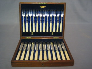 A 19th Century canteen of 12 silver plated fruit knives and forks contained in an oak canteen box