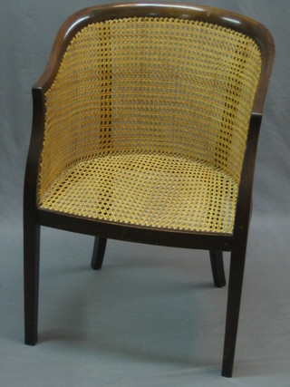 An Edwardian tub back library chair with caned seat and back