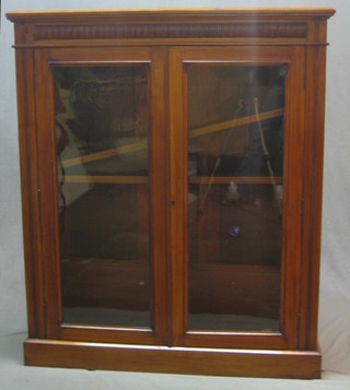 An Edwardian walnut bookcase, the interior fitted adjustable shelves enclosed by glazed panelled door, raised on a platform base 42"