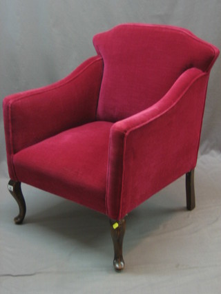 An Edwardian mahogany framed armchair upholstered in red material, raised on cabriole supports