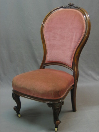 A Victorian walnut show frame nursing chair upholstered in pink Dralon, raised on cabriole supports