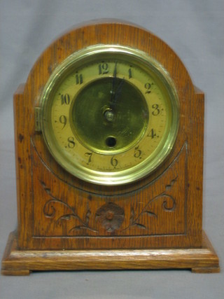 An American mantel clock with paper dial and Arabic numerals contained in an oak arch shaped case