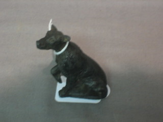 A metal figure of a seated dog 2 1/2"