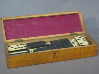 A box decorated a cribbage board containing a collection of dominoes