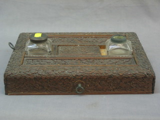A Burmese carved hardwood standish fitted 2 cut glass inkwells and with drawer to base 12"