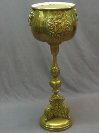 An embossed brass Dutch jardiniere with armorial decoration raised on a Rococo style column 40"
