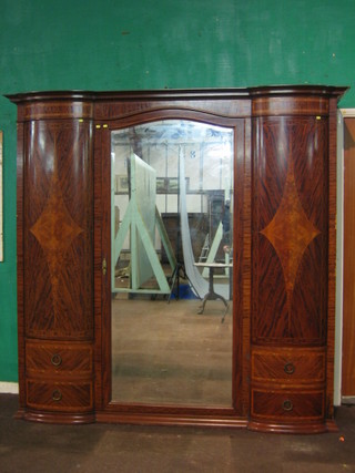 An Edwardian French inlaid mahogany triple wardrobe with moulded cornice, the centre section fitted an arch shaped mirror, flanked by a pair of cupboards above 2 short drawers 84"