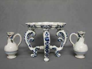 An 18th/19th Century shaped Delft pottery kettle stand of shaped outline, raised on 3 cabriole supports 6" together with 2 Delft spouted jugs 4/1"