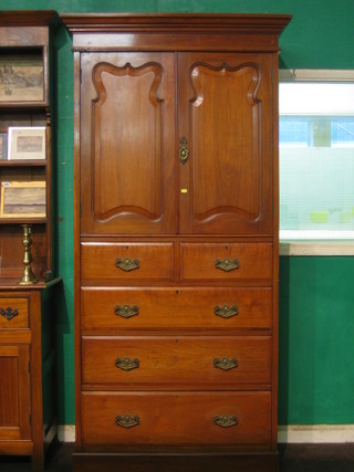 An Edwardian walnut cabinet on chest with moulded cornice, fitted shelves and enclosed by a panelled door, the base fitted 2 short and 3 long drawers, raised on a platform base 40" (possibly the centre section of a wardrobe)