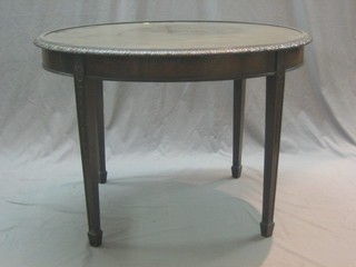 A Georgian style oval mahogany occasional table with carved border, raised on square tapering supports ending in spade feet 42"