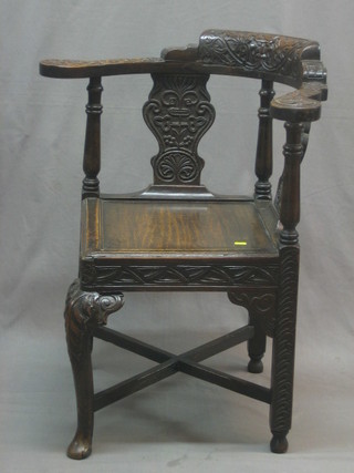 A Victorian heavily carved oak corner chair