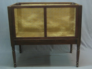 A  Victorian mahogany framed cot with cane panels to each side, raised on turned supports 42"