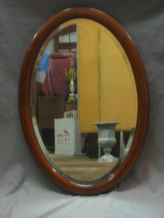 An Edwardian oval bevelled plate wall mirror contained in an inlaid mahogany frame 32"