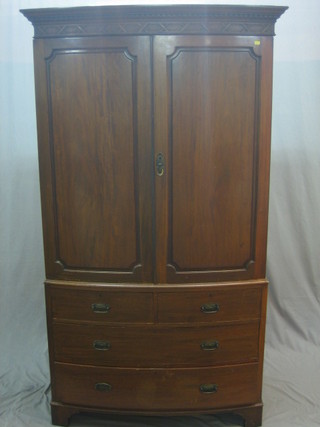 An Edwardian Georgian style mahogany bow front linen press with moulded and dentil cornice, the interior fitted 3 trays enclosed by panelled doors, the base fitted 2 short and 2 long drawers, raised on bracket feet 46"