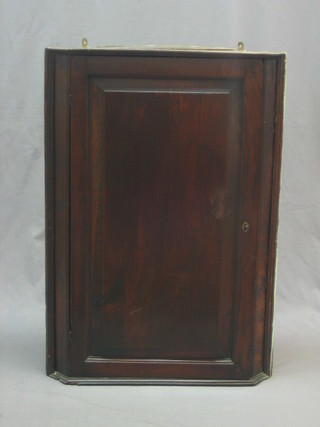An 18th/19th Century oak corner cabinet with shelved interior enclosed by a panelled door 25"