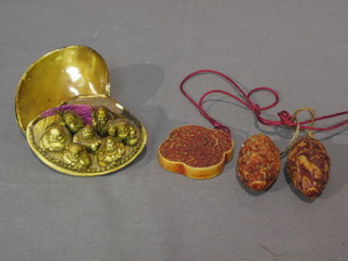 An Eastern carved pendant together with 2 other pendants and a plastic ornament in the form of a clam shell