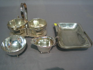 A circular planished silver plated sugar bowl, a silver plated sugar cream set, a silver plated cream jug and a plated cake basket with swing handle