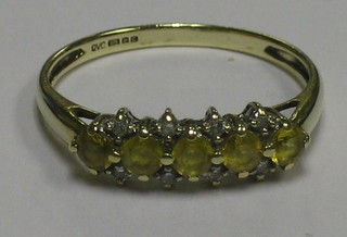 A lady's 9ct gold dress ring set 5 yellow sapphires supported by 8 diamonds
