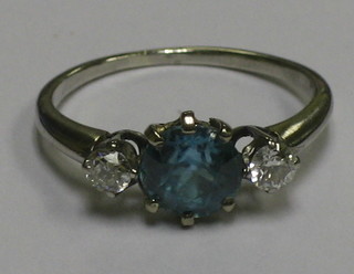 An 18ct white gold dress ring set a circular cut blue zircon supported by 2 circular diamonds
