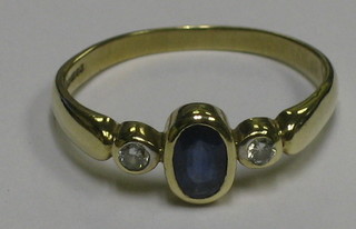 A lady's 9ct gold dress ring set a circular cut sapphire and 2 diamonds