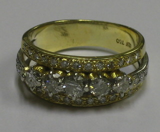 A lady's 18ct gold dress ring set 5 diamonds supported and surrounded by numerous other diamonds