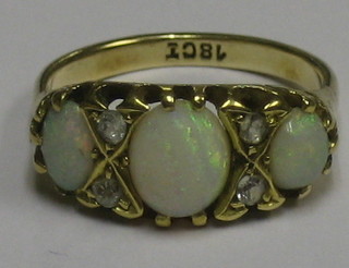A lady's 18ct gold dress ring set 3 oval cut opals supported by 4 diamonds