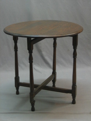 A 1930's oak oval folding coaching table, raised on turned and block supports 24"