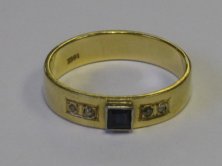An 18ct gold dress ring set a square cut sapphire supported by 4 diamonds