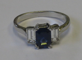 A lady's 18ct white gold dress ring set a rectangular cut sapphire supported by 2 baguette cut diamonds (approx 0.62/1.20ct)