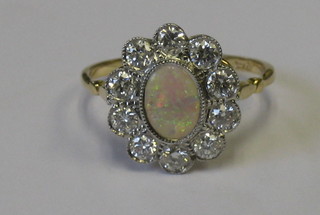 A lady's 18ct yellow gold dress ring set an oval cut opal surrounded by 10 diamonds (approx 0.90ct)