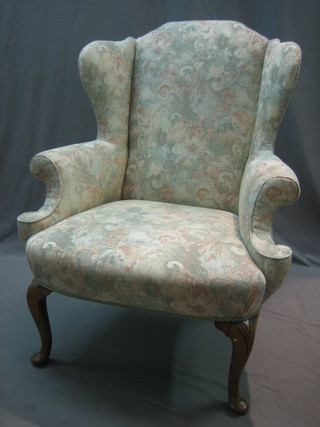 A Queen Anne style walnut framed armchair upholstered in floral material