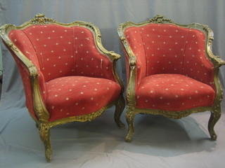 A pair of 19th/20th Century French gilt tub back armchairs upholstered in red material, raised on cabriole supports