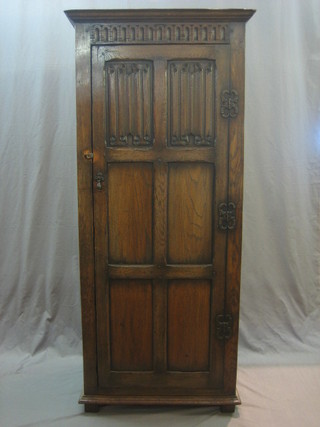An oak hall wardrobe with moulded cornice and linen fold decoration enclosed by a panelled door 30"