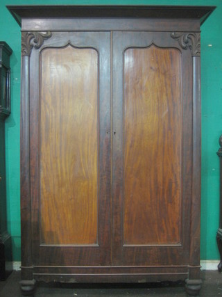 A 19th Century mahogany Channel Islands wardrobe with moulded cornice enclosed by panelled doors, raised on bun feet  62"