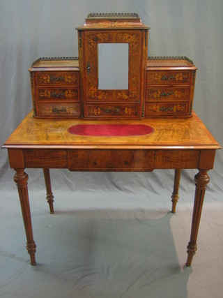 A 19th Century Continental inlaid walnut writing table with raised super structure to the back and brass three-quarter gallery, the centre section fitted a cupboard above 1 long drawer flanked by 6 short drawers, the writing surface above 1 long drawer, raised on turned and fluted supports 39"