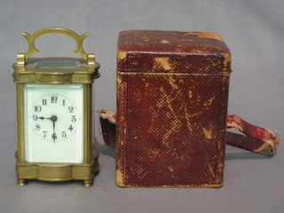 A 19th Century French 8 day carriage clock with enamelled dial and Arabic numerals contained in a shaped brass case 2" complete with leather carrying case