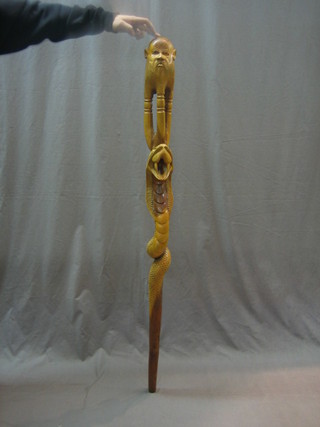 A curios carved Eastern walking stick in the form of a sage and serpent