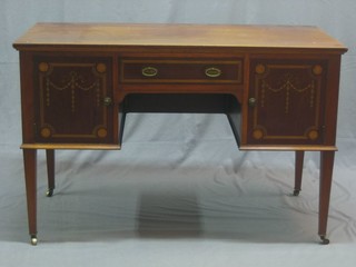 An Edwardian inlaid mahogany dressing table fitted 1 long drawer flanked by a pair of cupboards, raised on square tapering supports ending in brass caps and castors 48"