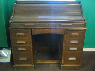 A 19th Century oak roll top desk with serpentine roll revealing a well fitted interior above 1 long and 8 short drawers 48"