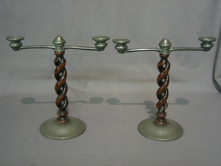 A pair of Tudric oak and planished pewter twin light candelabrum, raised on oak spiral turned columns, the base marked Tudric 013101 13"