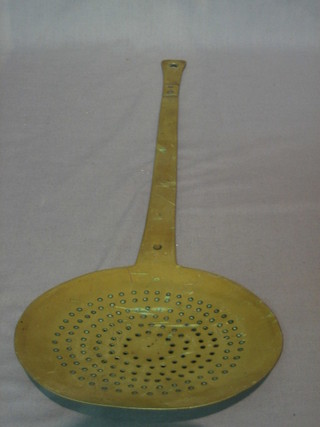 A circular pierced brass cream skimmer with old repair to handle