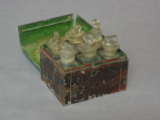 6 green glass bottles contained in a rectangular metal box